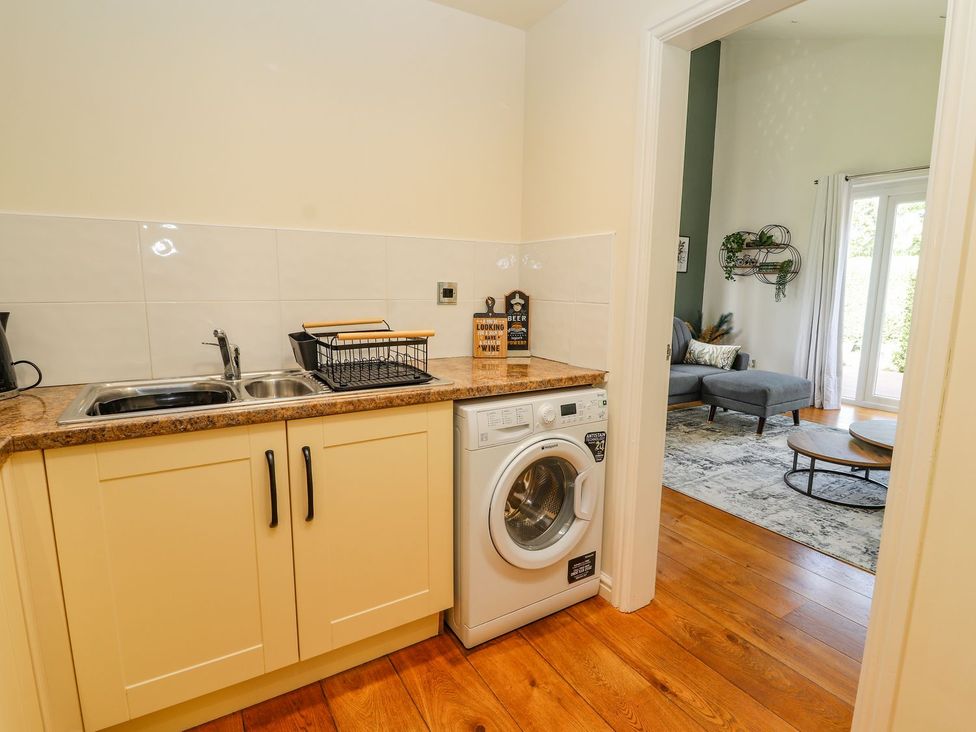 A laundry room with a washing machine and sink at Mount House Bryniau near Dyserth