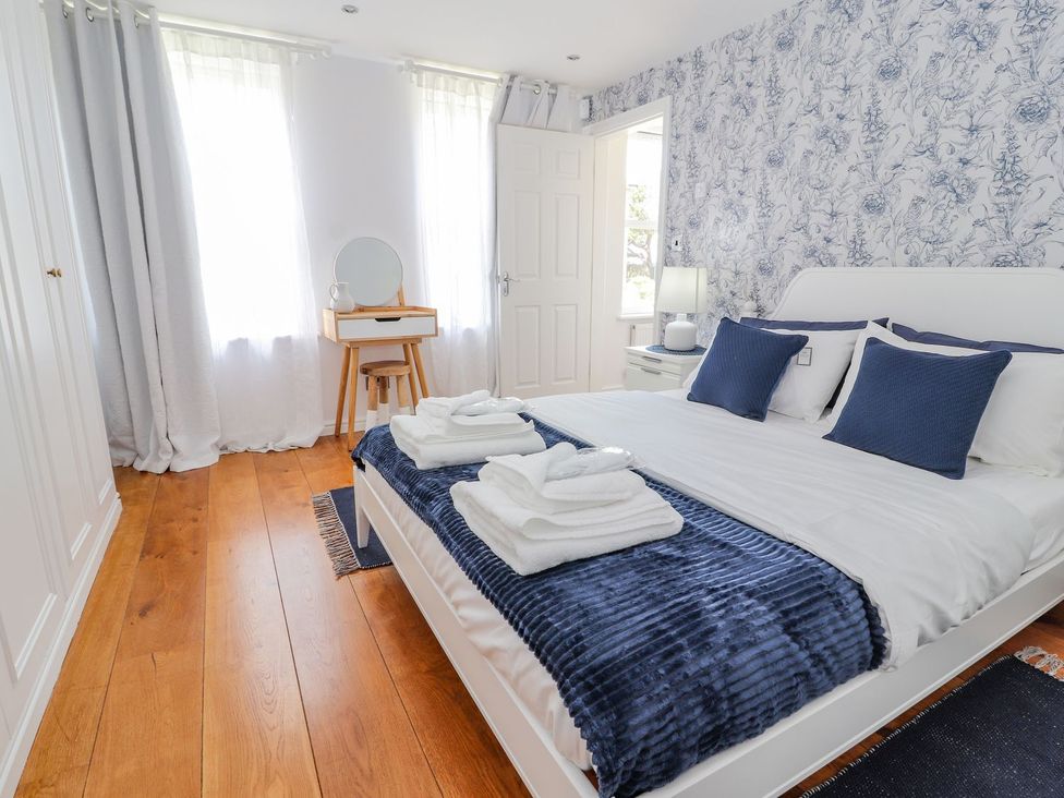A bedroom with a bed and a mirror at Mount House Bryniau near Dyserth