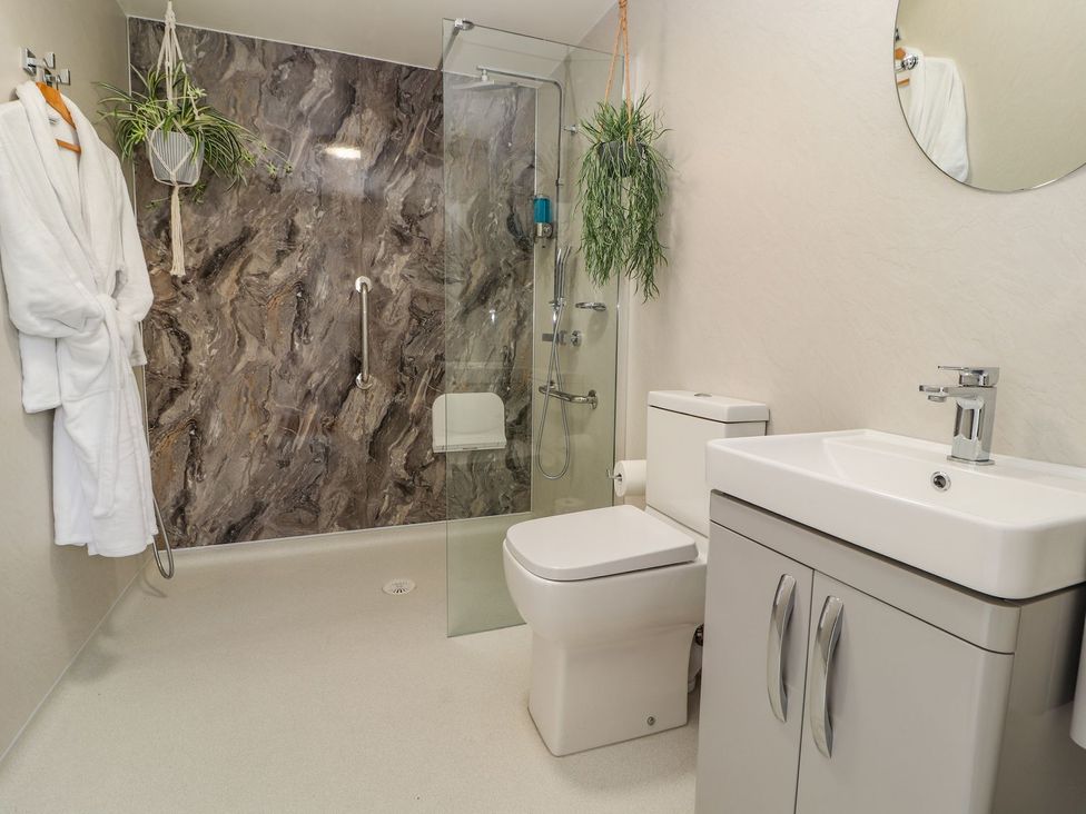 A bathroom with shower, toilet, sink and towel at Mount House Bryniau near Dyserth