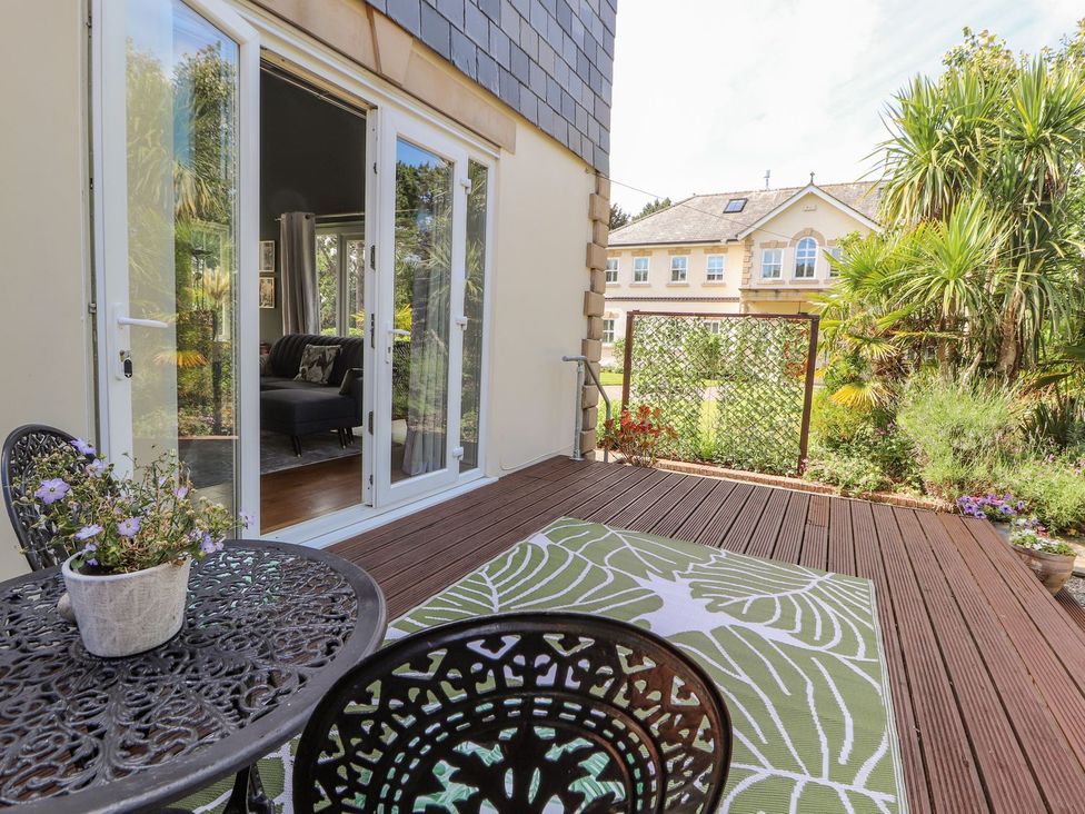 An outdoor patio with a table and chairs at Mount House Bryniau near Dyserth