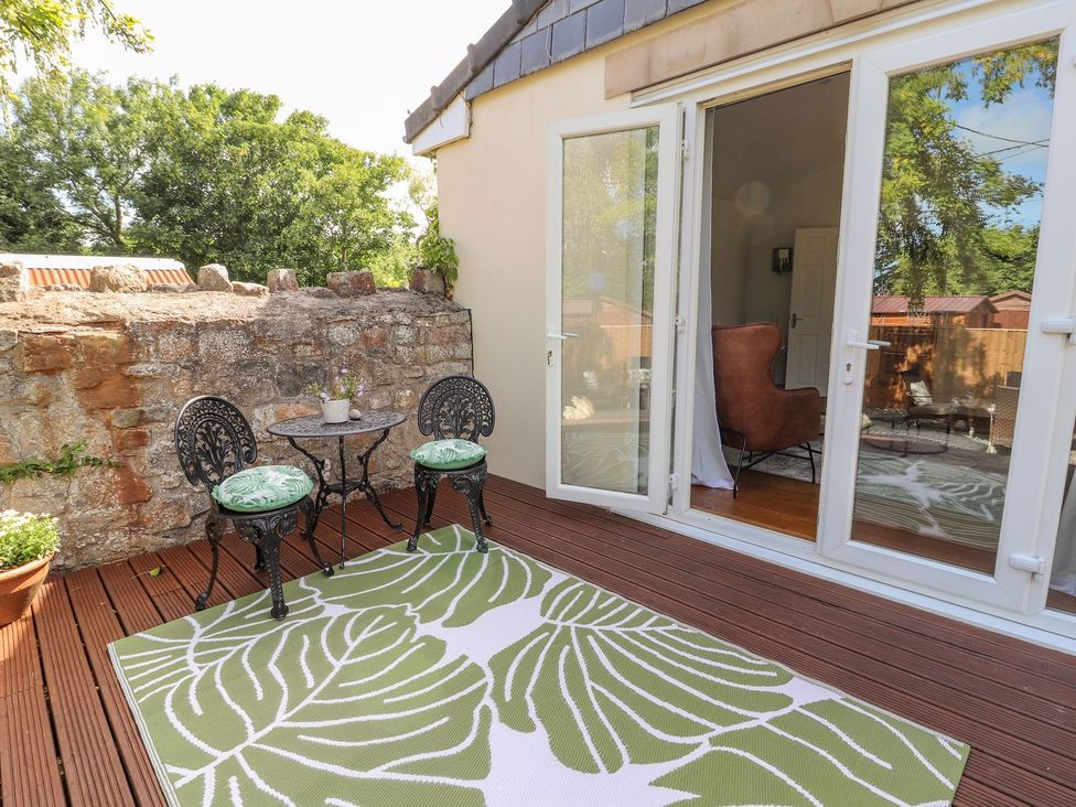 An outdoor seating area with a table and chairs at Mount House in Bryniau near Dyserth