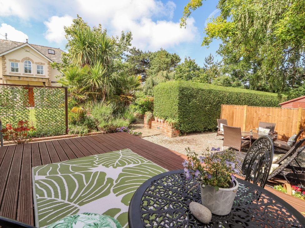 A garden with decking, table and chairs at Mount House Bryniau near Dyserth
