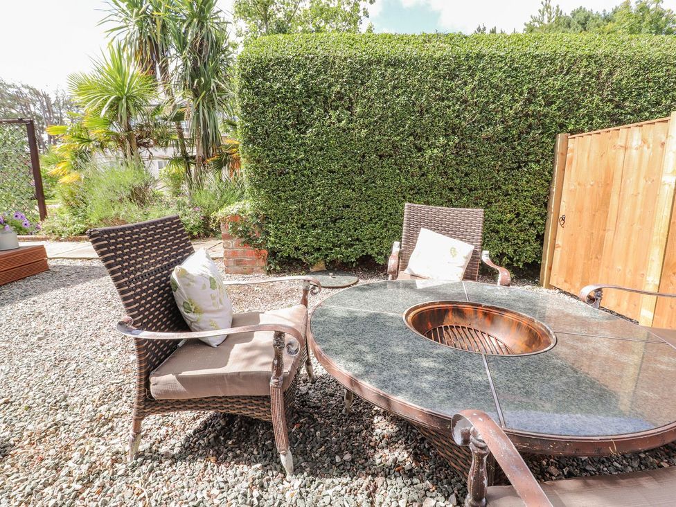 A garden with outdoor furniture and a fire pit at Mount House Bryniau near Dyserth