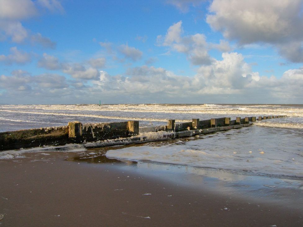 A beach with a pier and waves at Mount House in Bryniau near Dyserth