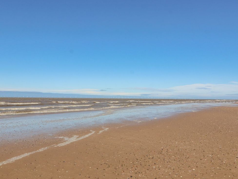 A beach with waves and sand at Mount House Bryniau near Dyserth