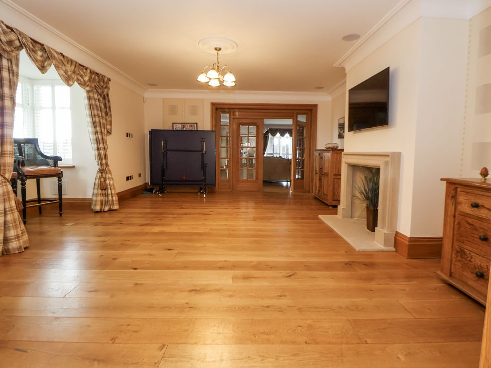 A living room with wooden flooring and a television at Mount House Bryniau near Dyserth