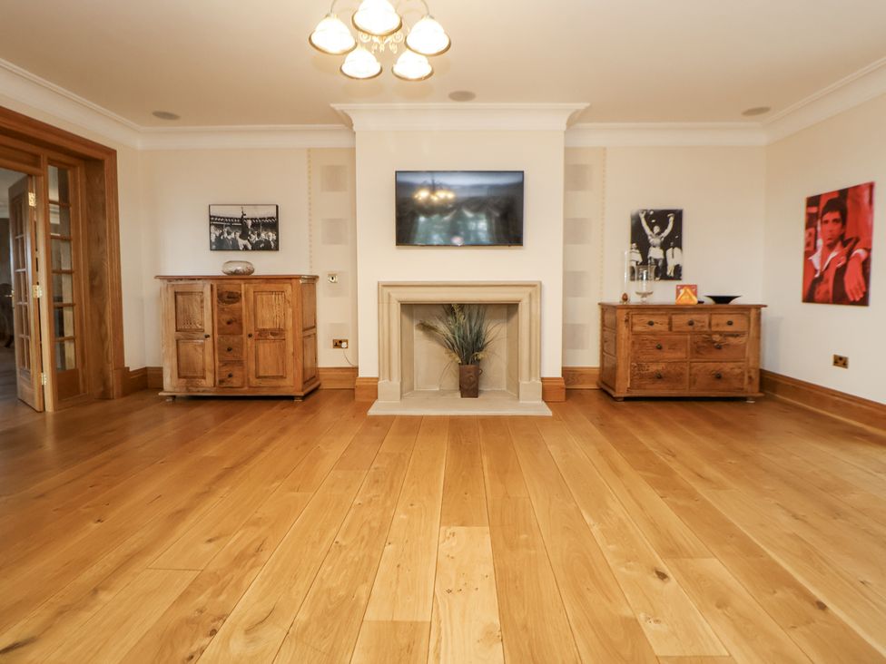 A living room with a fireplace and television at Mount House in Bryniau near Dyserth