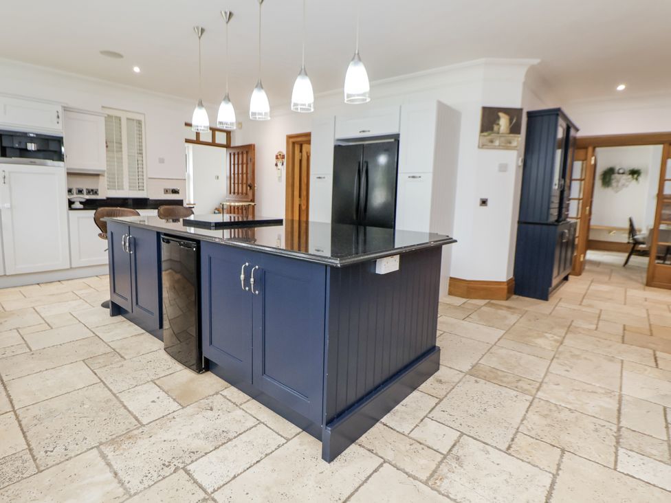 A kitchen with an island and refrigerator at Mount House Bryniau near Dyserth