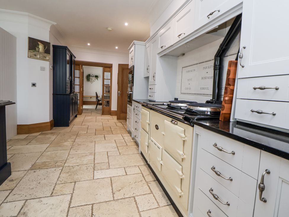 A kitchen with cabinets and a stove at Mount House Bryniau near Dyserth