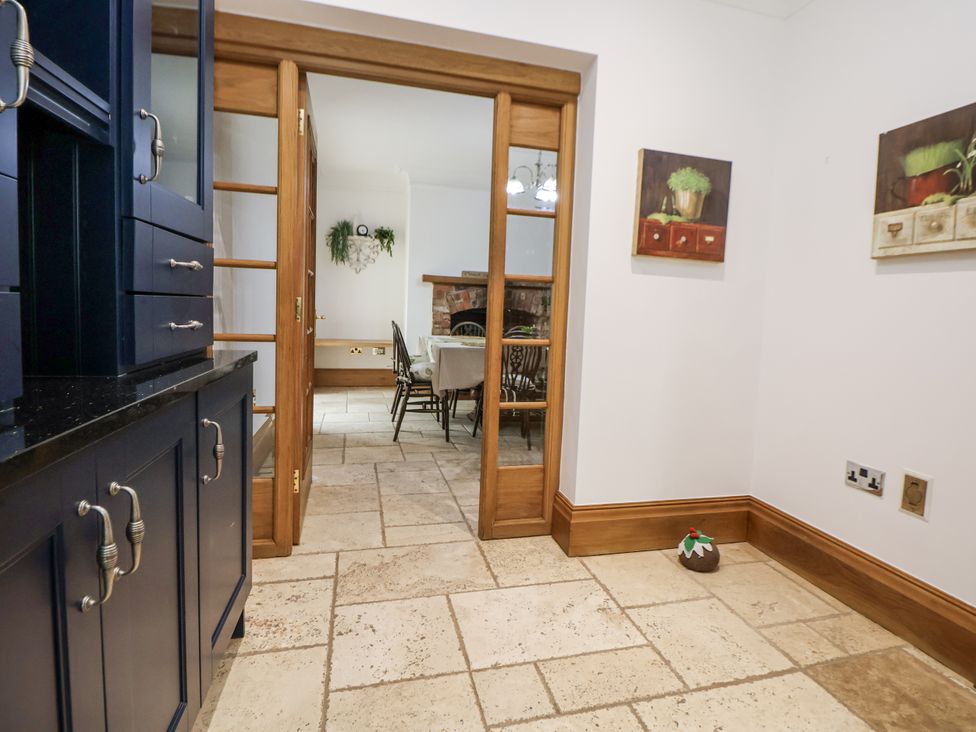 A dining room with a cabinet and table at Mount House Bryniau near Dyserth