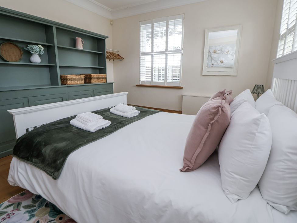 A bedroom with a bed and shelves at Mount House Bryniau near Dyserth