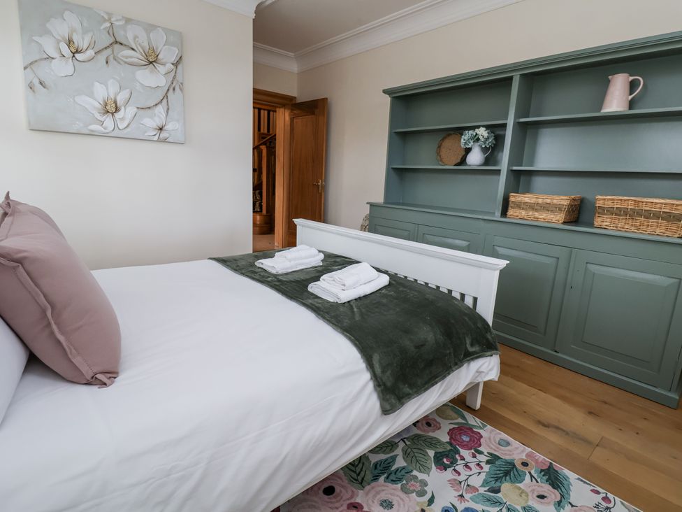 A bedroom with a bed and shelf at Mount House Bryniau near Dyserth