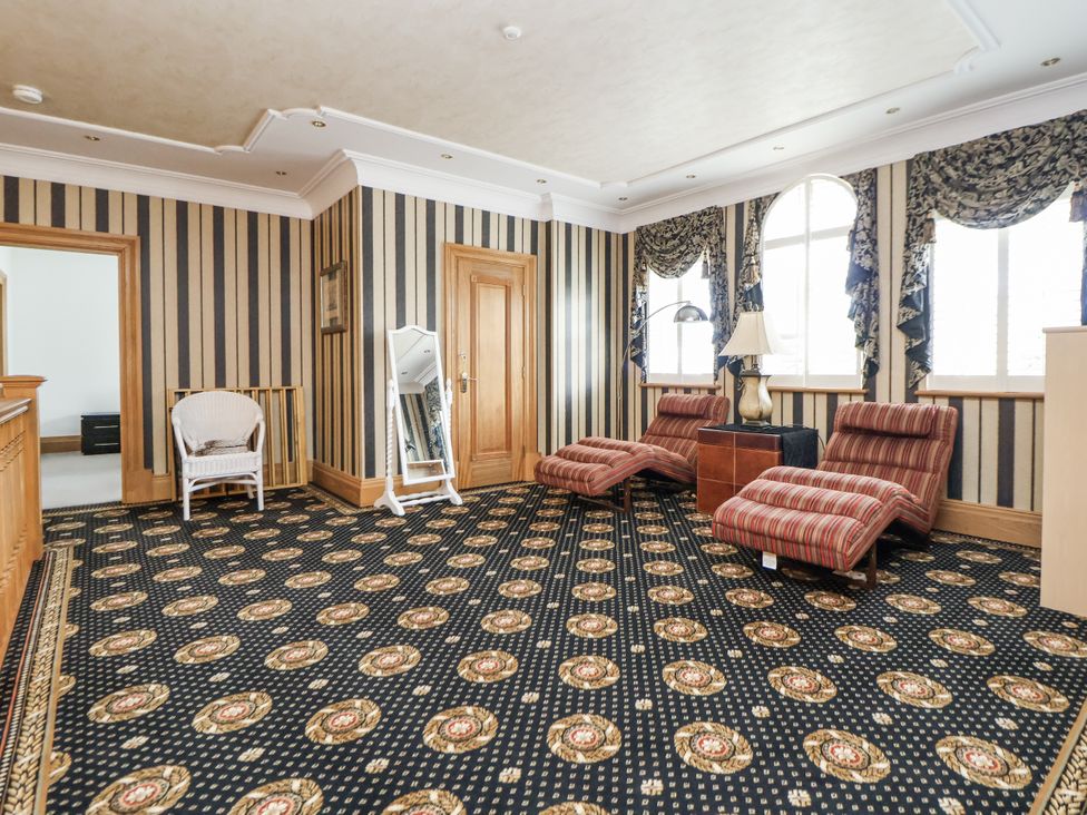 A sitting room with chairs and a lamp at Mount House in Bryniau near Dyserth