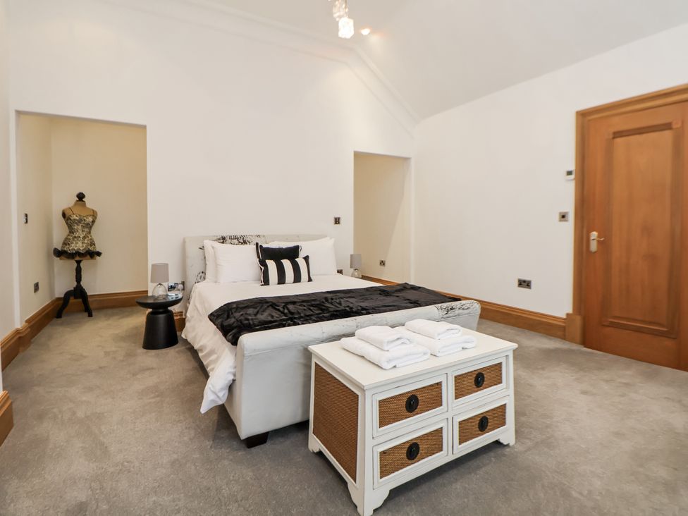 A bedroom with a bed and towels on a dresser at Mount House in Bryniau near Dyserth