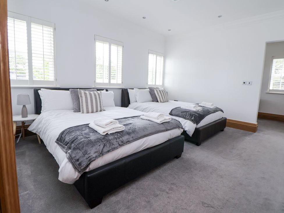 A bedroom with two beds and a nightstand at Mount House Bryniau near Dyserth