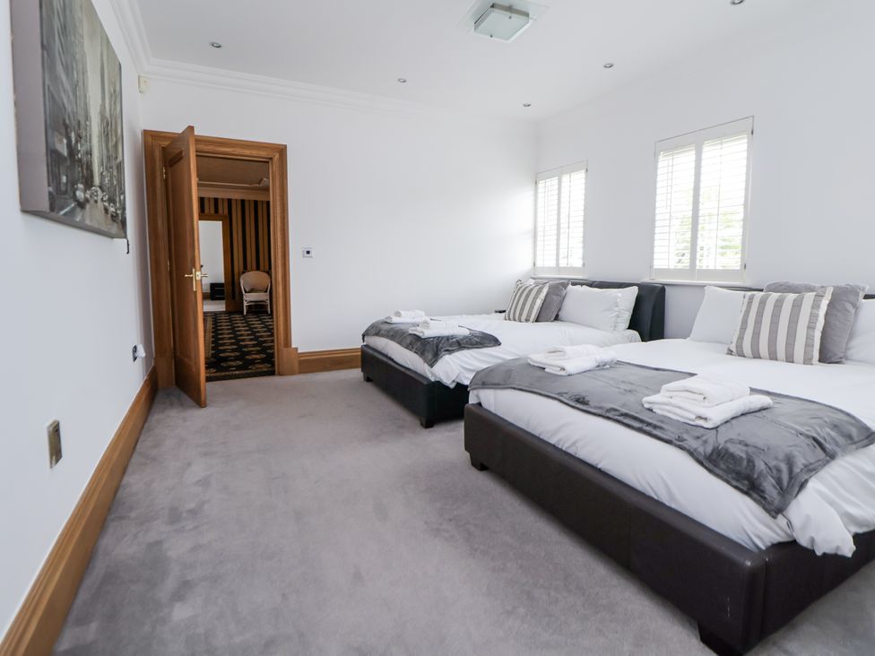 A bedroom with two beds and a door at Mount House Bryniau near Dyserth