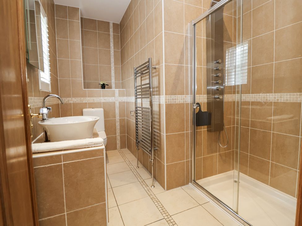 A bathroom with a bathtub, toilet, shower, and sink at Mount House in Bryniau near Dyserth