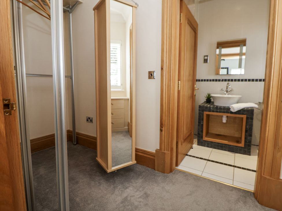 A bathroom with a sink and mirror at Mount House in Bryniau near Dyserth