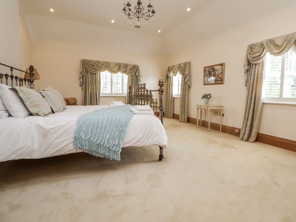 A bedroom with a bed and bedside lamp at Mount House in Bryniau near Dyserth