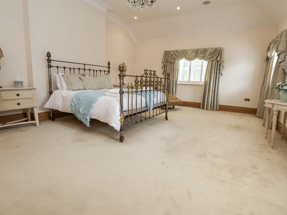 A bedroom with a bed and bedside table at Mount House in Bryniau near Dyserth