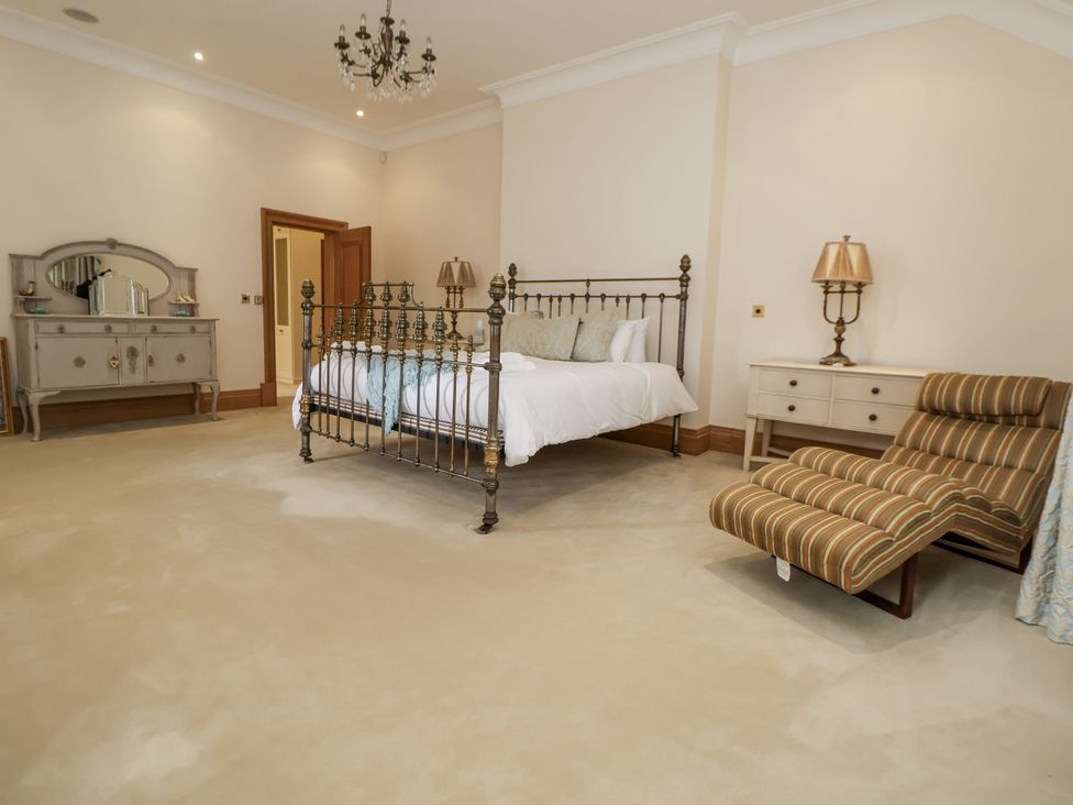A bedroom with a metal bed and dresser at Mount House in Bryniau near Dyserth