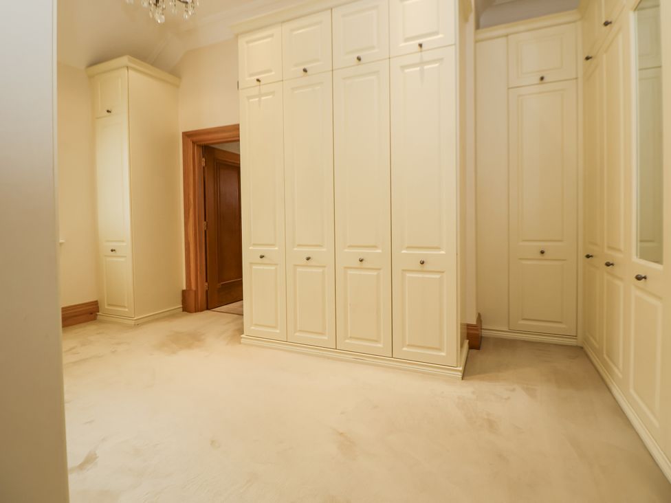 A dressing room with built-in wardrobes at Mount House Bryniau near Dyserth