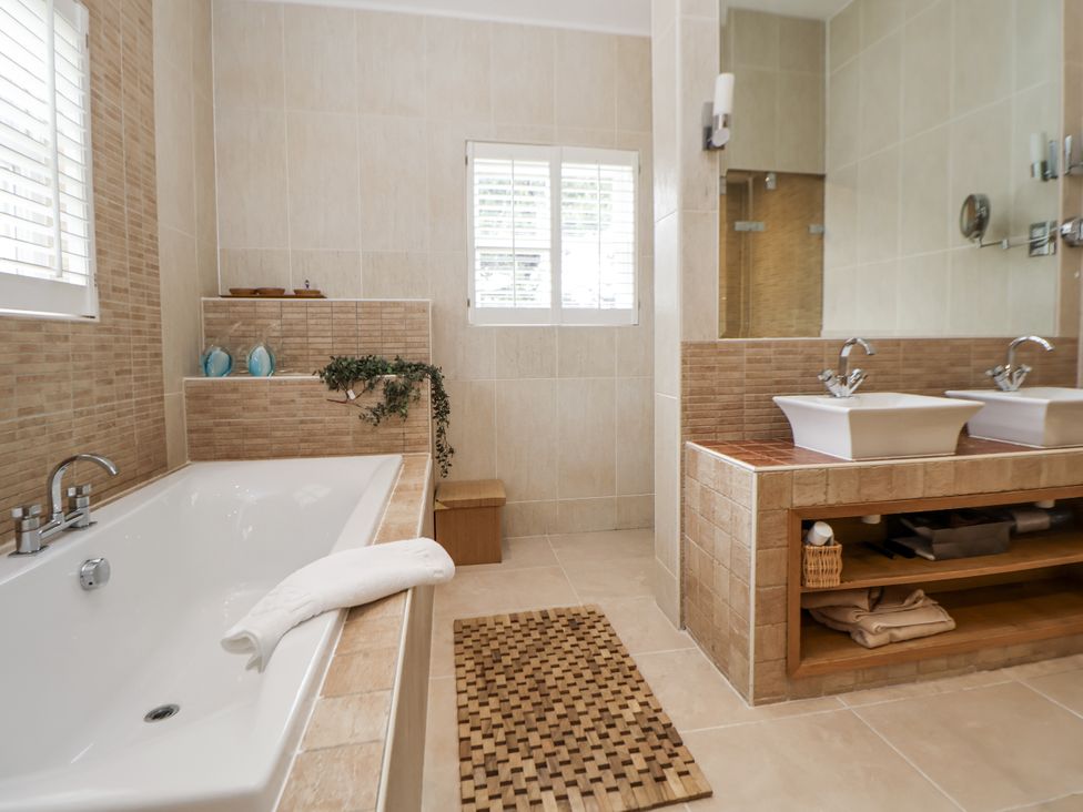 A bathroom with a bathtub and double sinks at Mount House in Bryniau near Dyserth