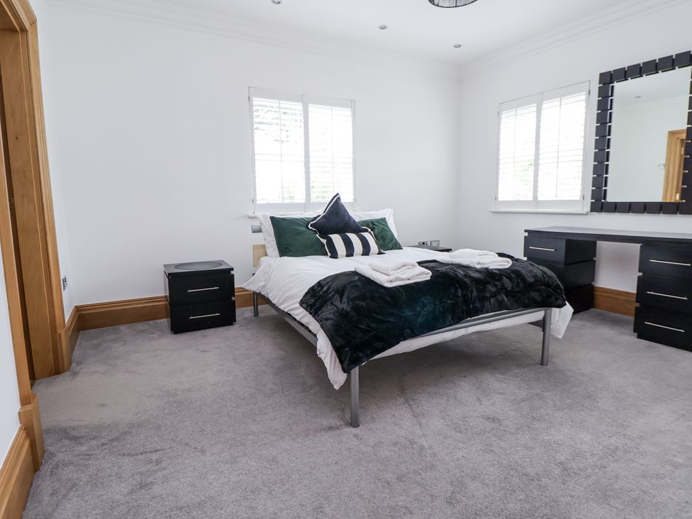 A bedroom with a bed and nightstand at Mount House Bryniau near Dyserth