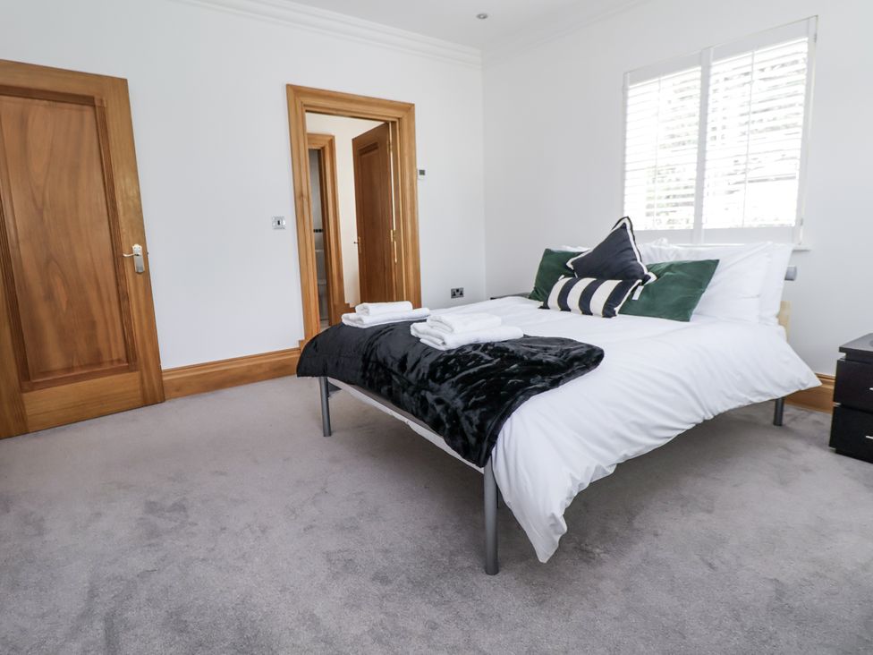A bedroom with a bed and nightstand at Mount House Bryniau near Dyserth