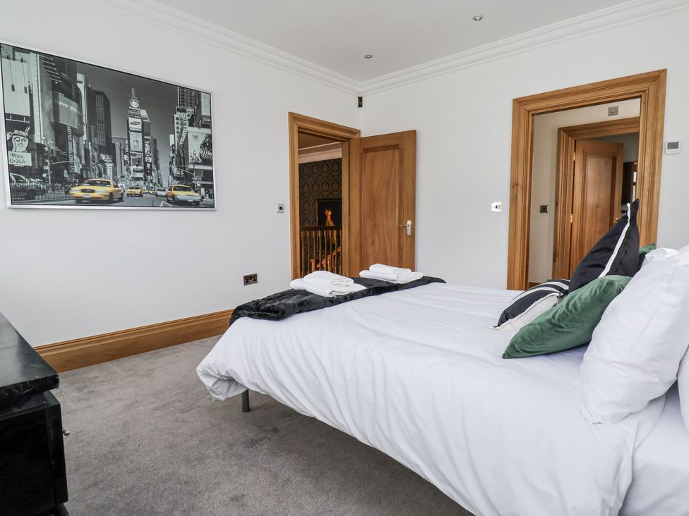 A bedroom with a bed and towels at Mount House Bryniau near Dyserth