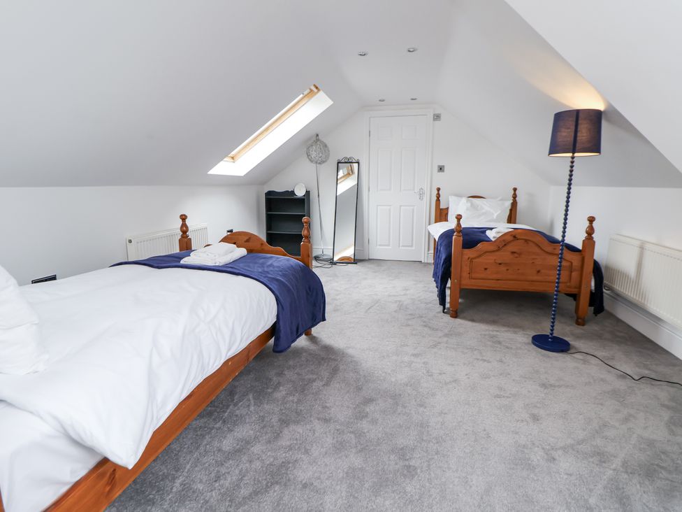 A bedroom with two beds and a mirror at Mount House Bryniau near Dyserth