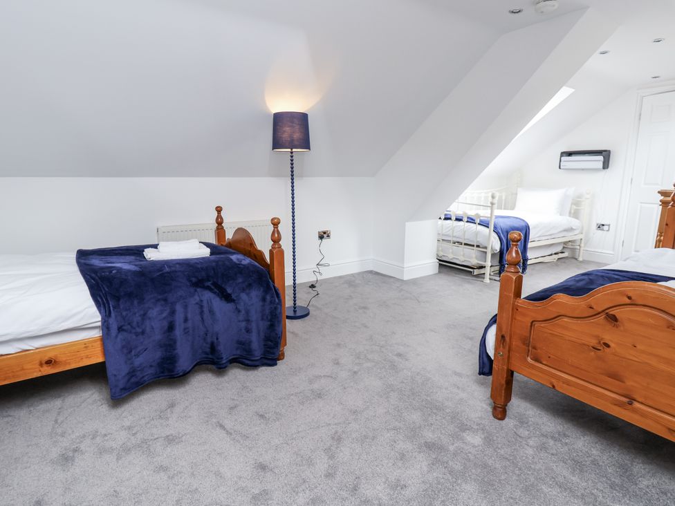 A bedroom with two beds and a lamp at Mount House in Bryniau near Dyserth