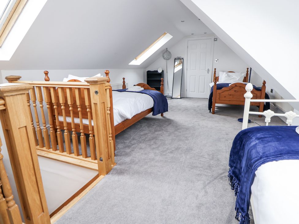 A bedroom with two beds and a mirror at Mount House Bryniau near Dyserth