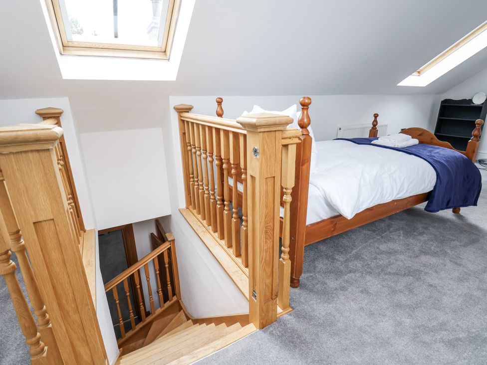 A bedroom with a bed and stairs at Mount House Bryniau near Dyserth