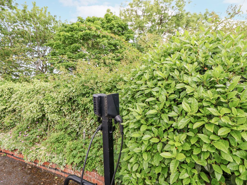An outdoor charging station near bushes at Mount House in Bryniau near Dyserth