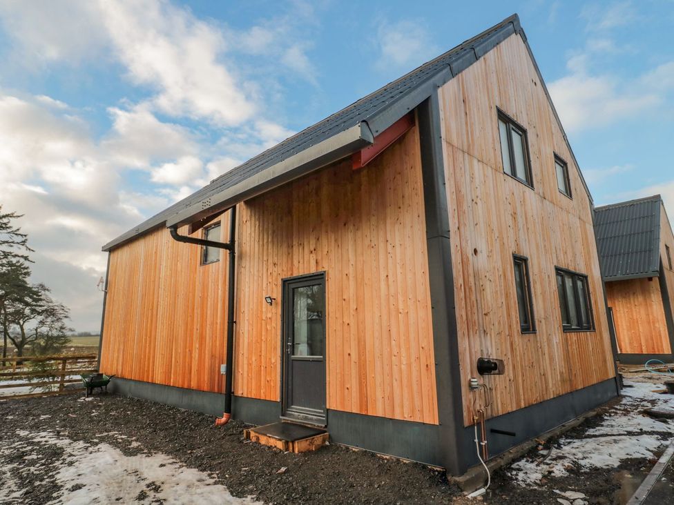 An exterior view of a building with wooden cladding at Harvest Cottage 1 in Berwick-upon-Tweed