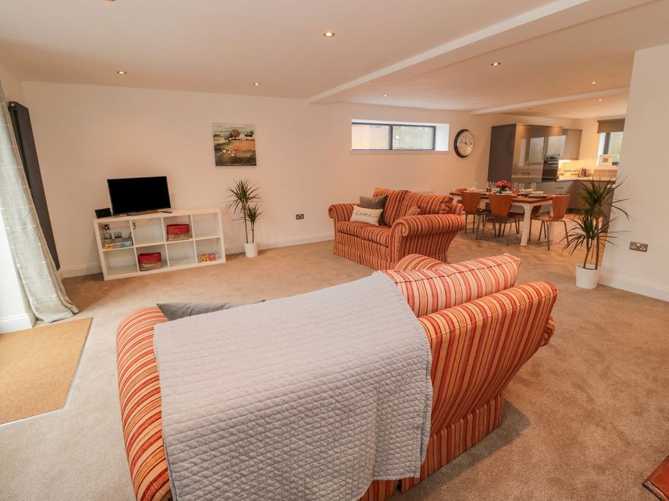 A living room with a sofa and television at Harvest Cottage 1 in Berwick-upon-Tweed