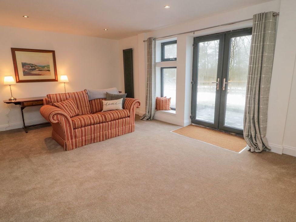 A living room with a sofa and lamp at Harvest Cottage 1 Berwick-upon-Tweed