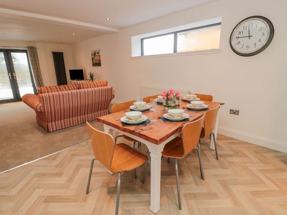 A dining room with a wooden table set for six at Harvest Cottage 1 in Berwick-upon-Tweed