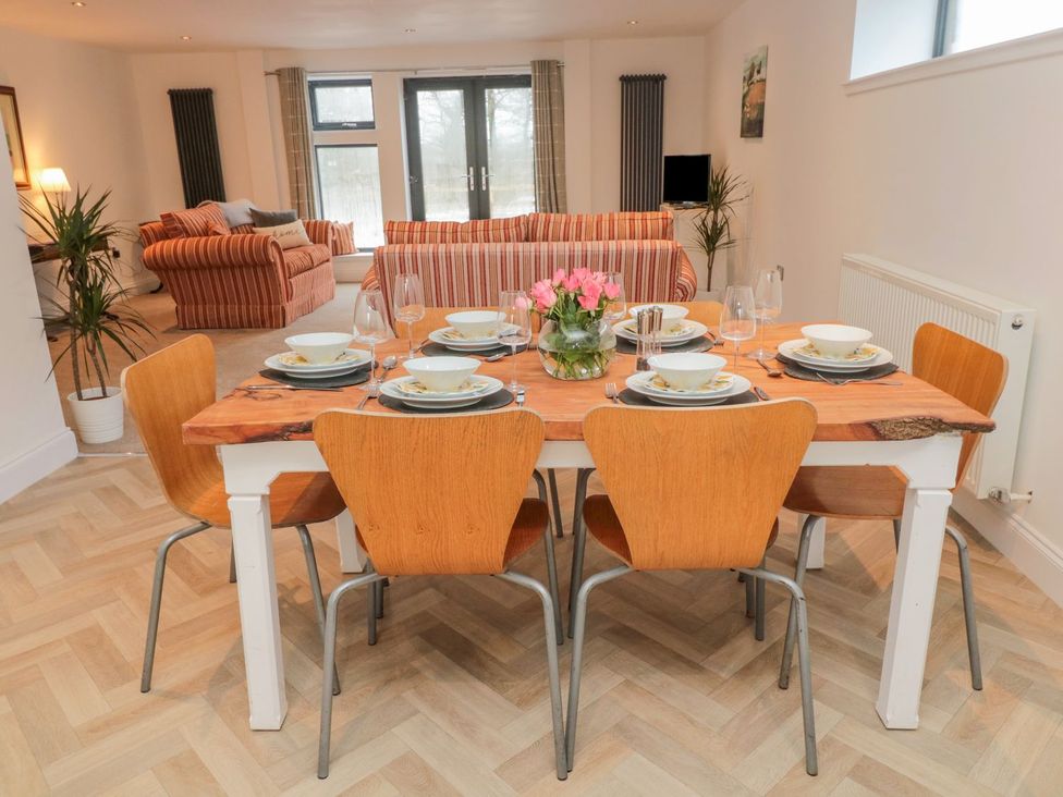 A dining table set with plates and glasses at Harvest Cottage 1 in Berwick-upon-Tweed