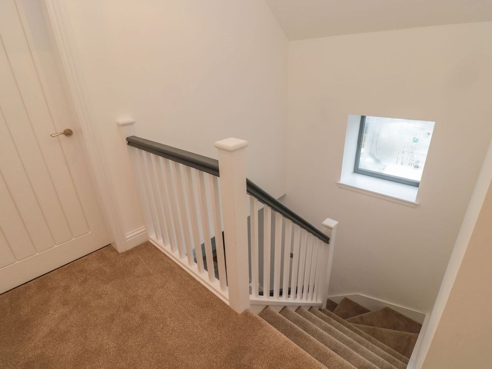 A staircase with a railing and a window at Harvest Cottage 1 in Berwick-upon-Tweed