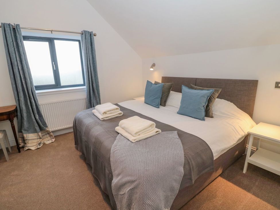 A bedroom with a bed and window at Harvest Cottage 1 Berwick-upon-Tweed