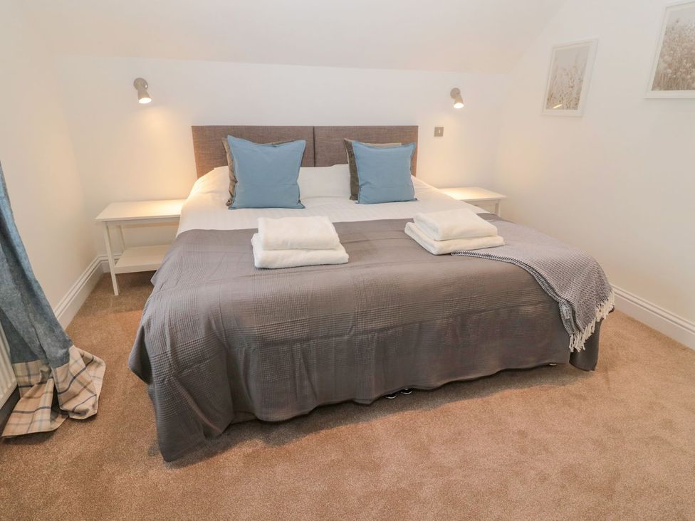 A bedroom with a bed and bedside table at Harvest Cottage 1 in Berwick-upon-Tweed