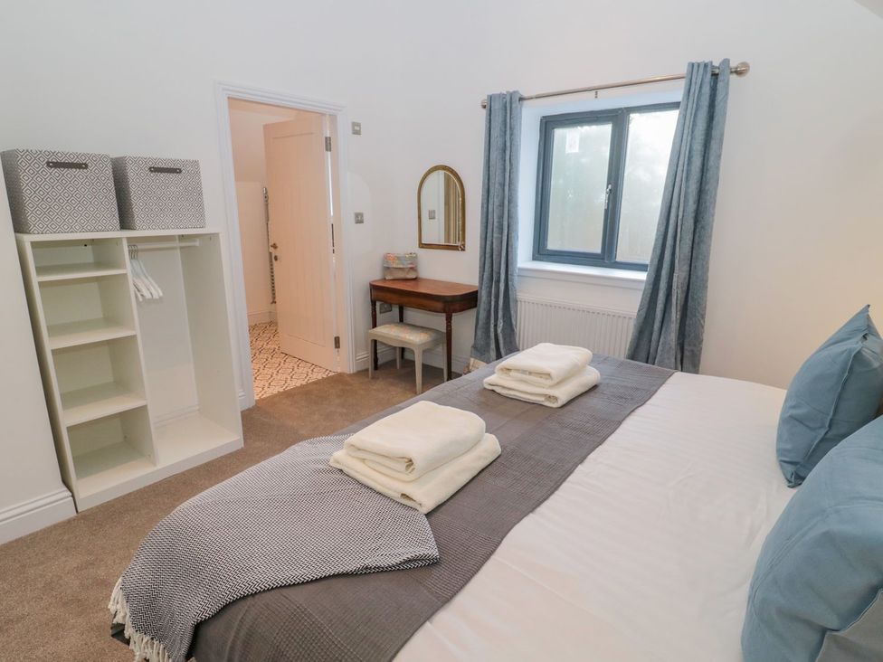 A bedroom with a bed and towels at Harvest Cottage 1 in Berwick-upon-Tweed