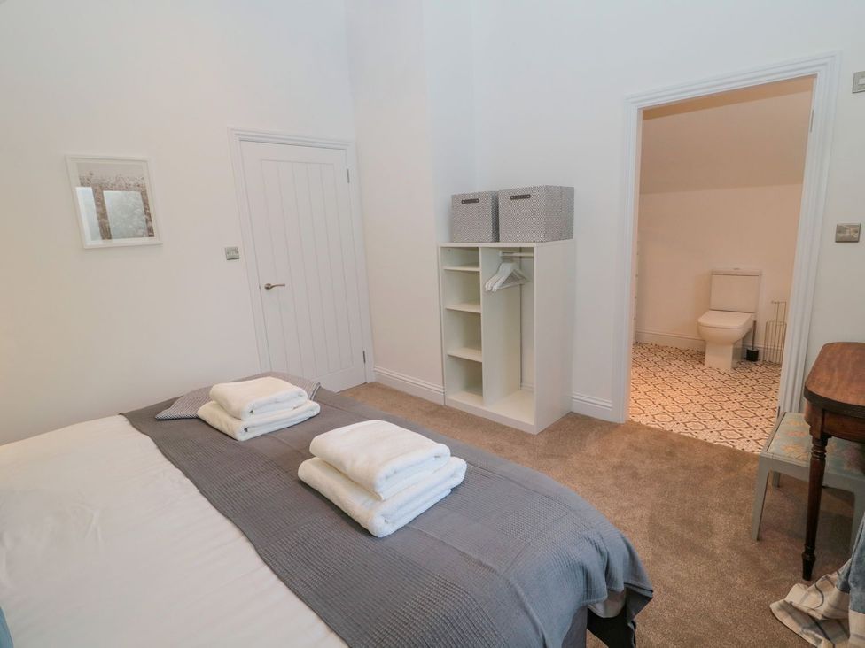 A bedroom with a bed and towels folded on top at Harvest Cottage 1 in Berwick-upon-Tweed