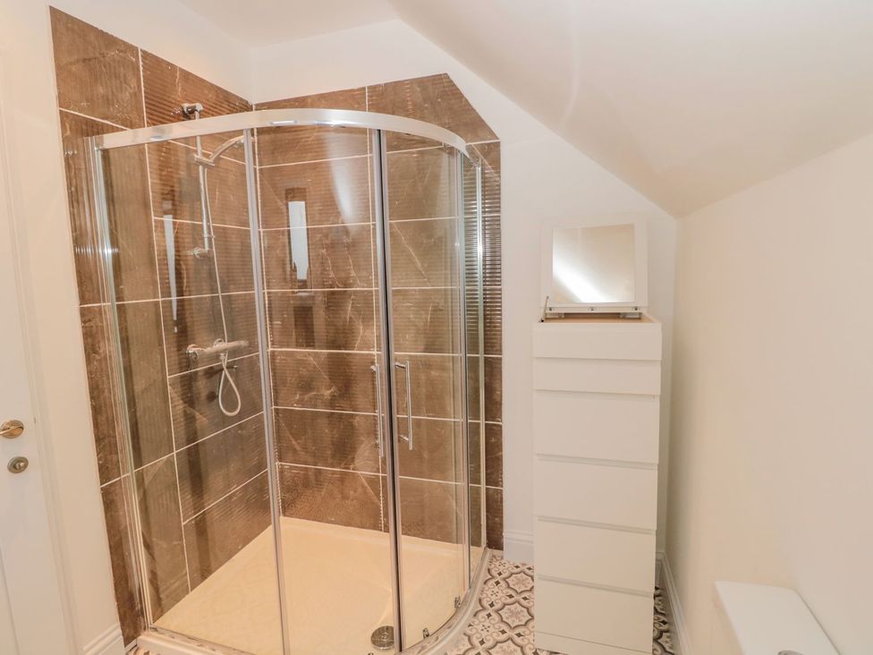 A bathroom with a shower and cabinet at Harvest Cottage 1 in Berwick-upon-Tweed