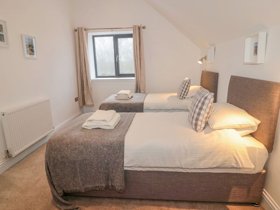 A bedroom with twin beds and a window at Harvest Cottage 1 in Berwick-upon-Tweed