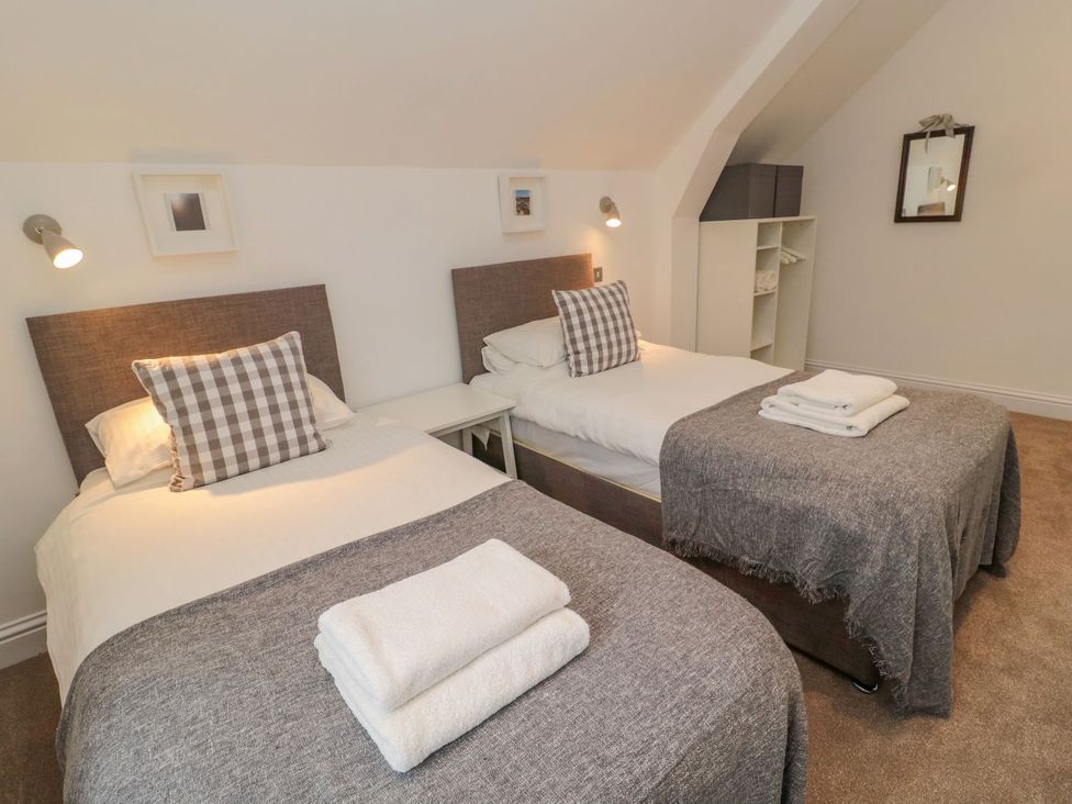 A bedroom with two beds and bedside tables at Harvest Cottage 1 in Berwick-upon-Tweed