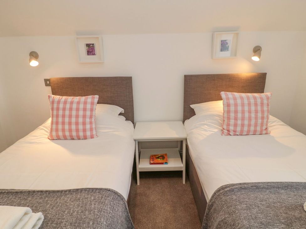 A bedroom with two beds and a nightstand at Harvest Cottage 1 Berwick-upon-Tweed