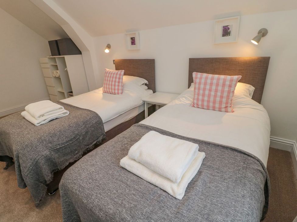 A bedroom with two beds and a bedside table at Harvest Cottage 1 in Berwick-upon-Tweed